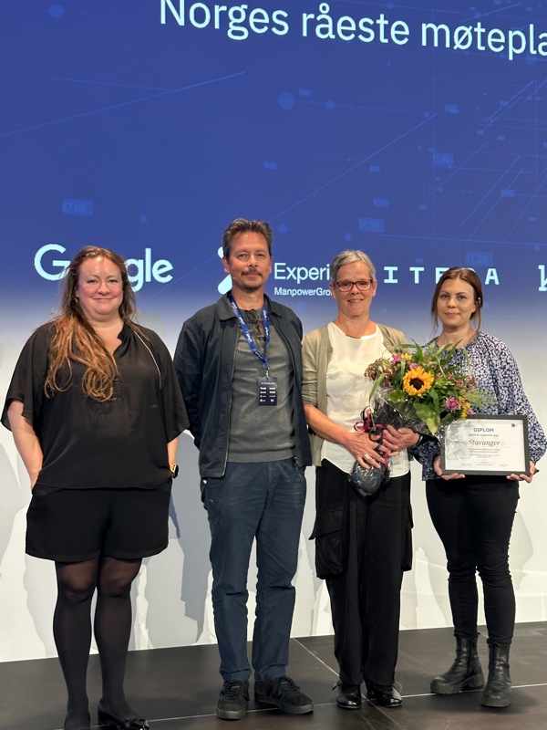 Kommunens ansatte Eva Jenseg og Sølvi Alice Nilsen tar i mot prisen som årets KI kommune