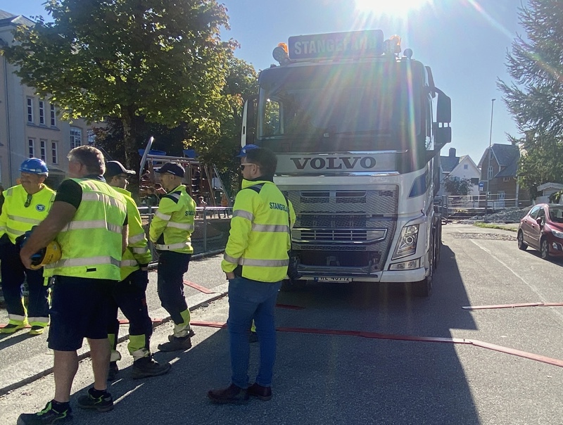 Menn fra Stangeland Maskin i gule jakker framfor en stor lastebil