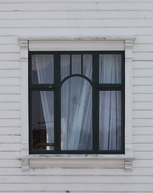 Et pent, gammelt, mørkegrønt vindu i jugendstil.