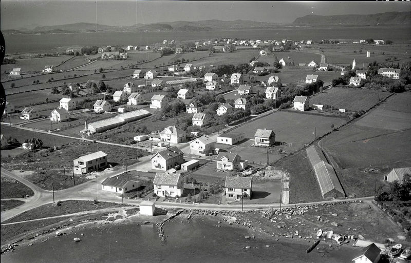 Flyfoto av Hundvåg sett fra over Galeivågen og nordover mot Rennesøy. Øya er stort sett jordbruksland og hus i store hager.