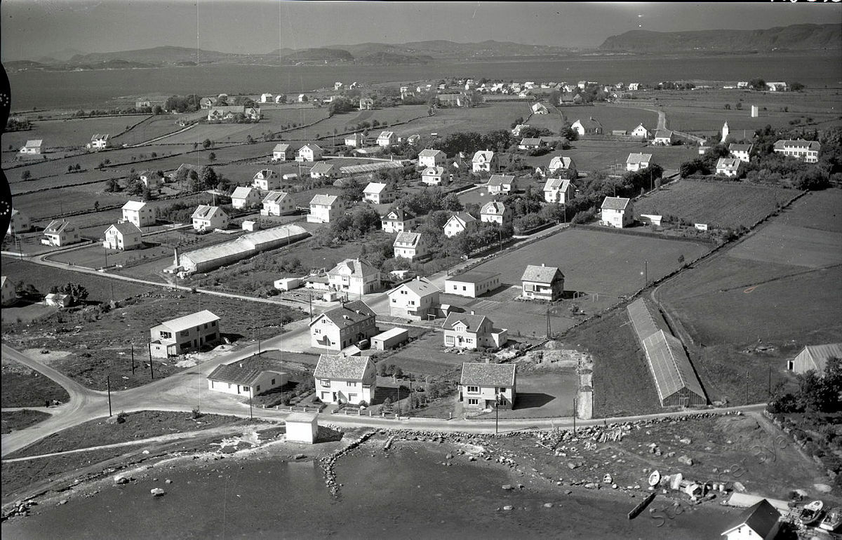 Flyfoto av Hundvåg sett fra over Galeivågen og nordover mot Rennesøy. Øya er stort sett jordbruksland og hus i store hager.