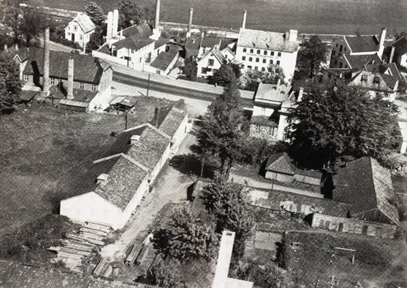 Køhlereiendommen sett fra vest i fugleperspektiv. Bildet er svart-hvitt, og er tatt i sommerhalvåret, siden det er løv på trærne.  Hillevågsveien ligger over Køhlereiendommen i bildet, og det er flere industribygg og bolighus mellom Hillevågsveien og Gandsfjorden, som synes øverst i bildet. Industribygningene har høye piper.