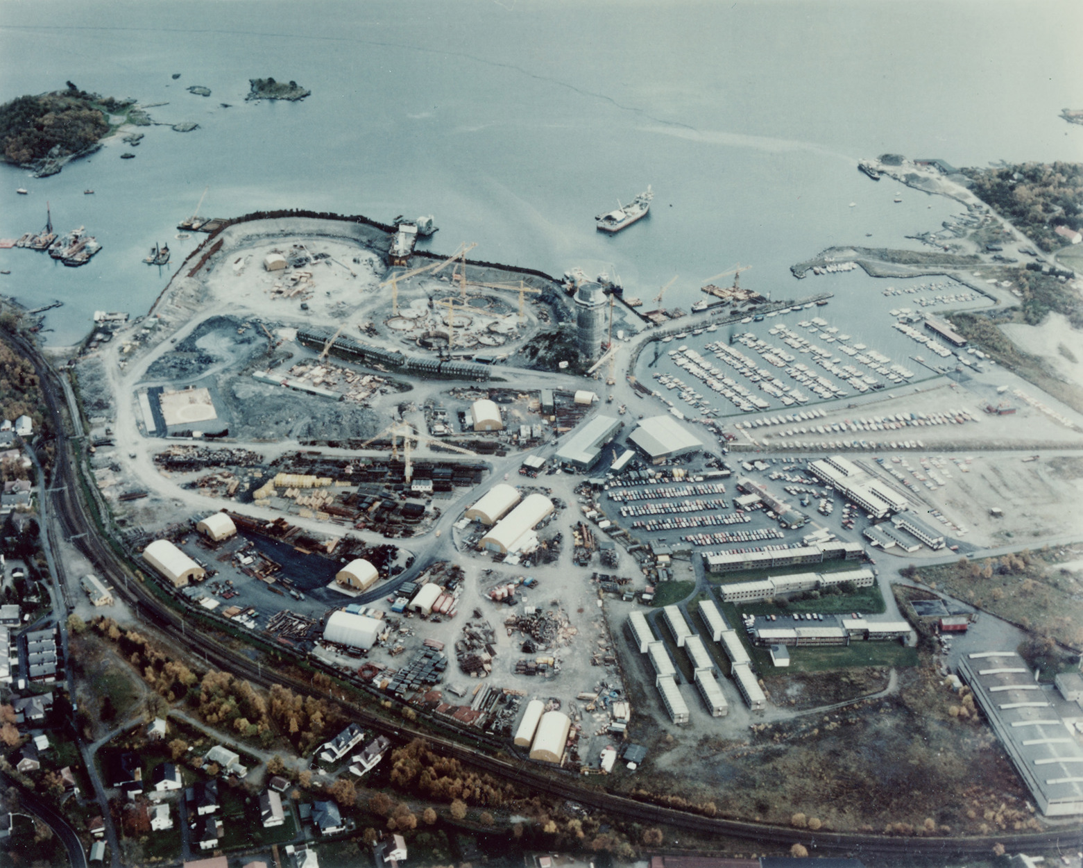 Et flyfoto over Jåttåvågen med plattformbygging og småbåthavn. Jærbanen ses i nedre bildekant, og Gandsfjorden ligger øverst, med friområdet på Vaulen ivenstre bildekant.