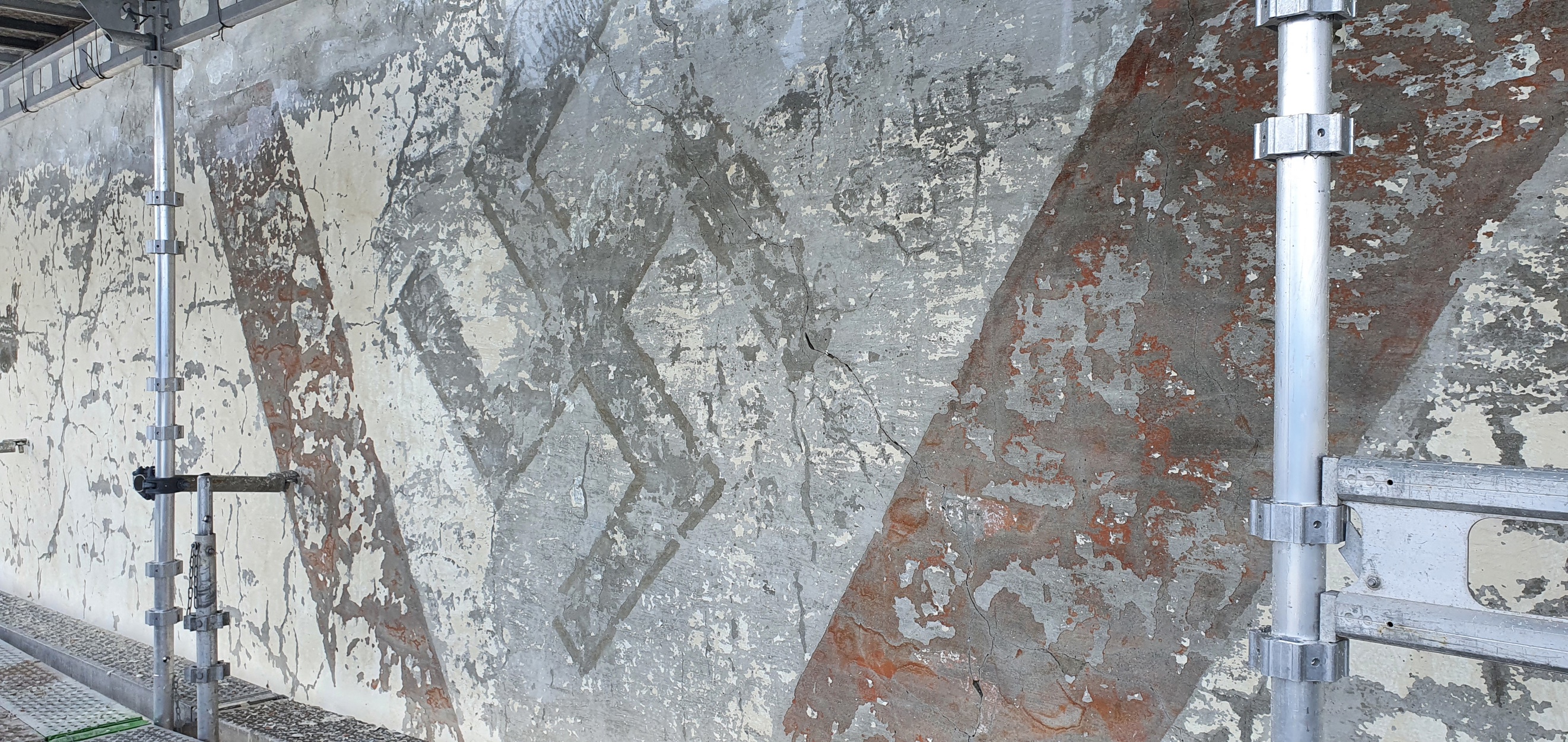 Et hakekors av delvis avflasset maling/murpuss.