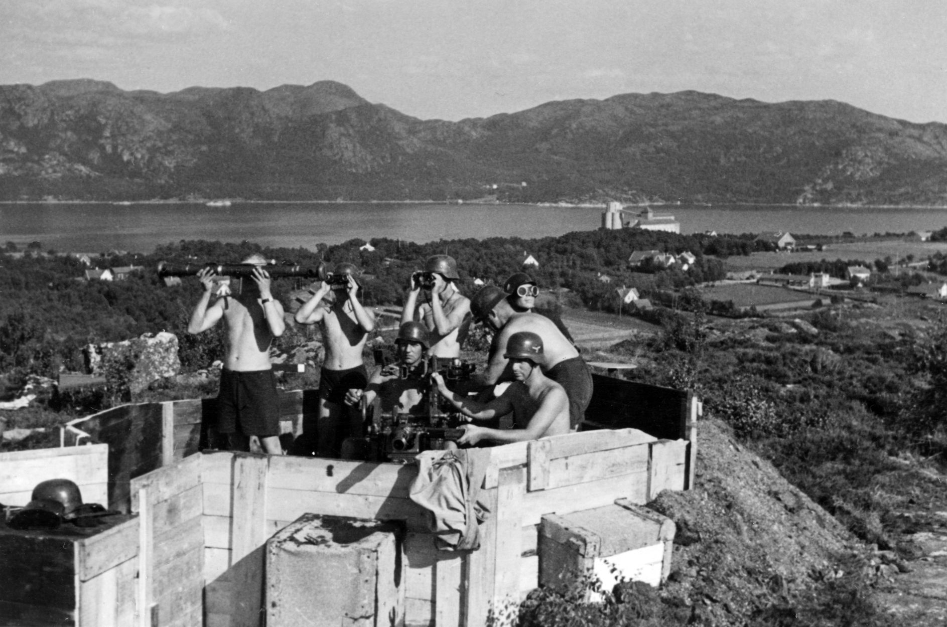 Tyske soldater følger med på himmelen fra luftvernstilling på Ulsberget. Tydeligvis en varm sommerdag, siden de er svært lettkledd.