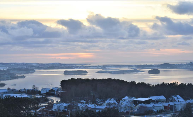 Hafrsfjord i vintersolnedgang. Hustaka har et tynt lag snø, og fjorden er nærast spegelblank.