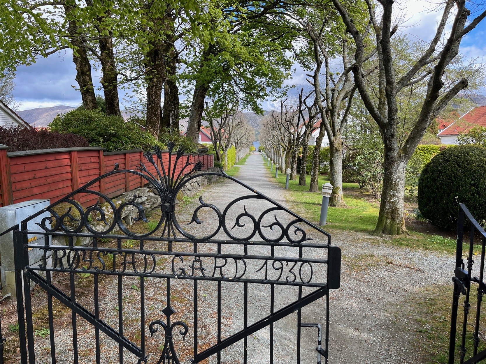 Port med skriften "Frøystad Gård" leder inn til en allé.
