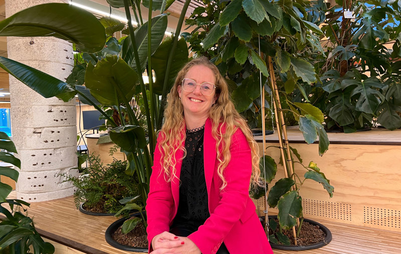 Heather Bergsland sittende blant planter. 