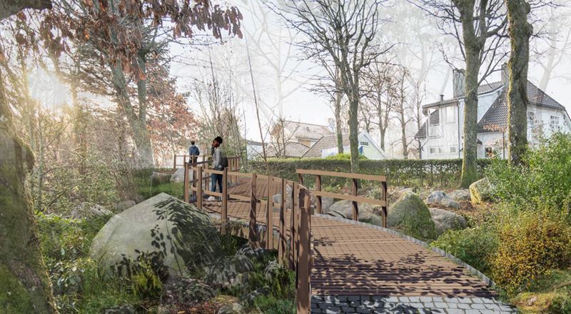 Tursti med trebru over steinete natur, mellom store eldre trær.