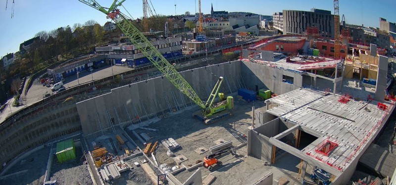 Byggeplass med betongvegger og heisekran sett ovenfra.