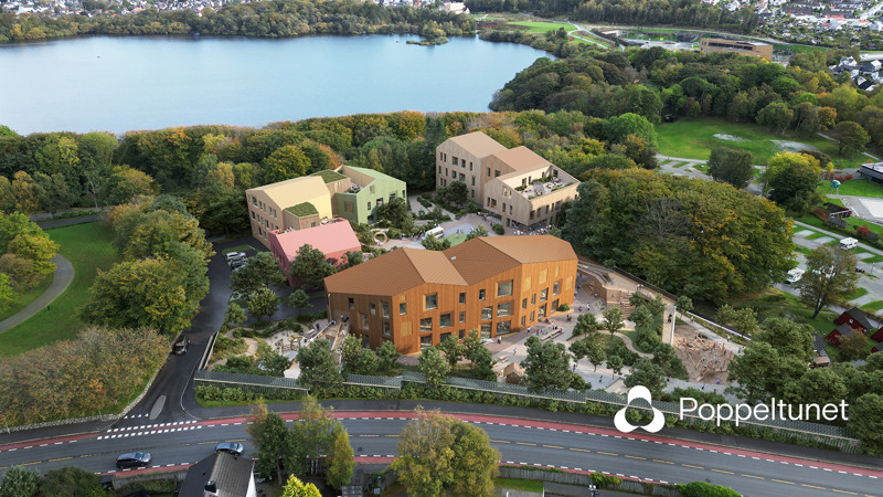 Tre bygg i grønne omgivelser sett skrått ovenfra. I bakgrunnen skimtes Mosvatnet. I forgrunnen en bilvei.