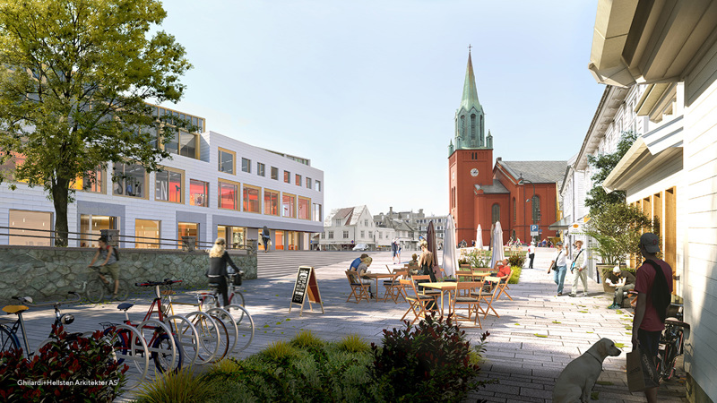 Åpen plass under trær, med sittergrupper, uteservering, en syklist og noen som går.