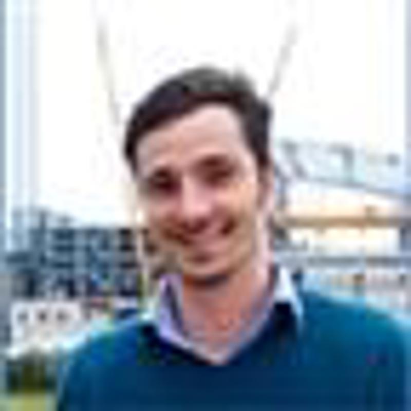 Ansiktet til en smilende ung mann med kort mørkt hår.