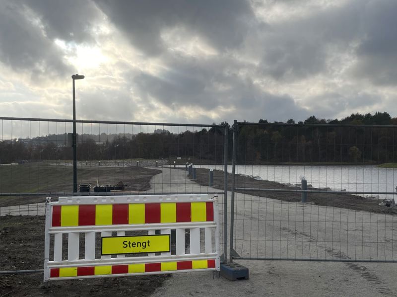 ny trusti ved vann er stengt med skilt og anleggsgjerde