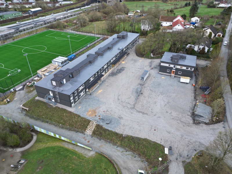 Dronebilde av skolen. Motoveien i bakgrunnen