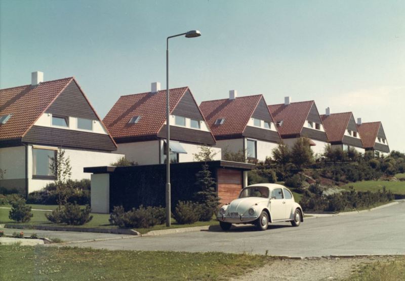 Karakteristiske svartbeisede, kjedede eneboliger med hvite murer og røde tegltak i Stokkabrautene. To bjørketrær i gata står uten løv.