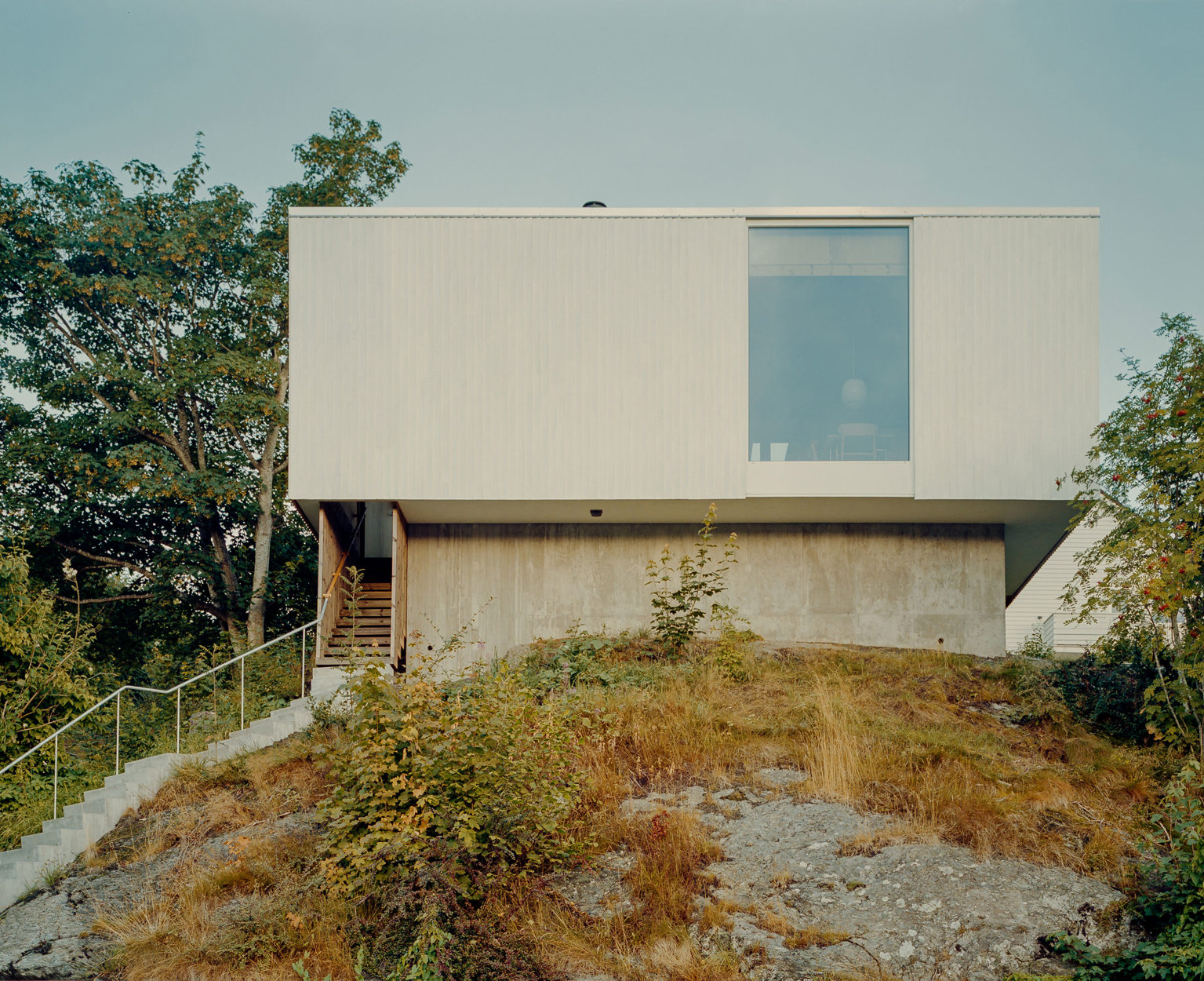Huset sett utenfra, og lang trapp opp fra fortauet. Ett vindu i fasaden.
