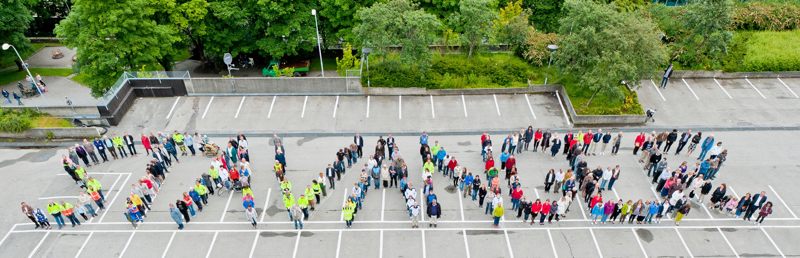 Bilde viser en gruppe mennesker på en parkeringsplass som former bokstavene i bynavnet STAVANGER.