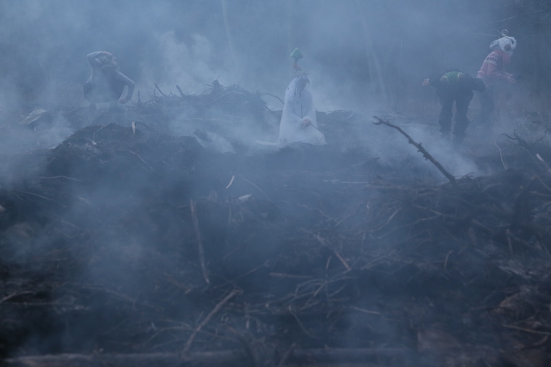 Fire personer med kostymer i et tåkefullt landskap.