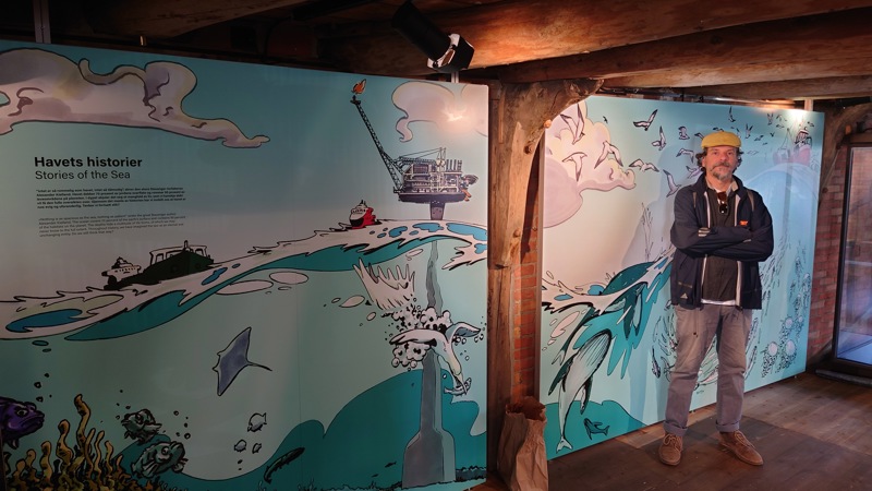 Leo Ribeiro smiler foran ett av verkene sine. 