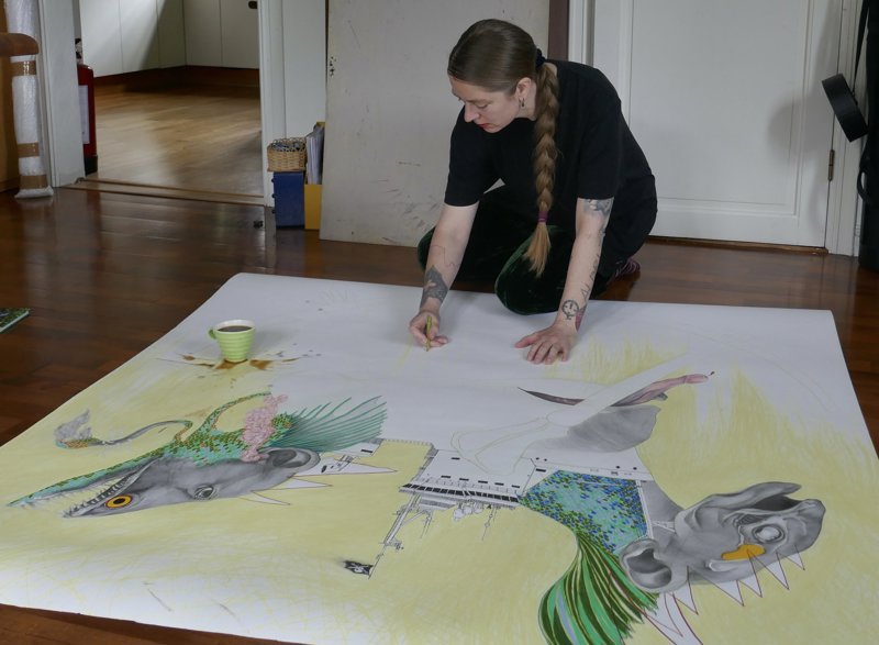 Brynhild Winther tegner på et stort ark. 