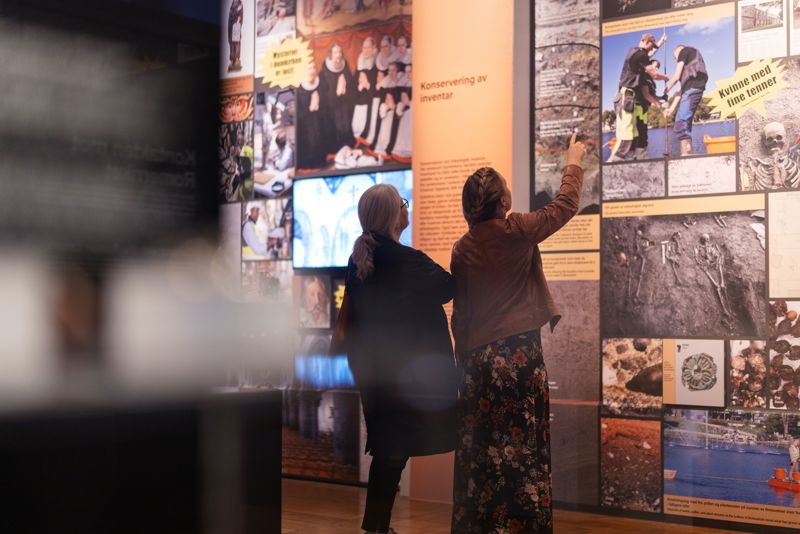 Katedralens hemmeligheter, folk ser på en utstillingsvegg på Arkeologisk museum.