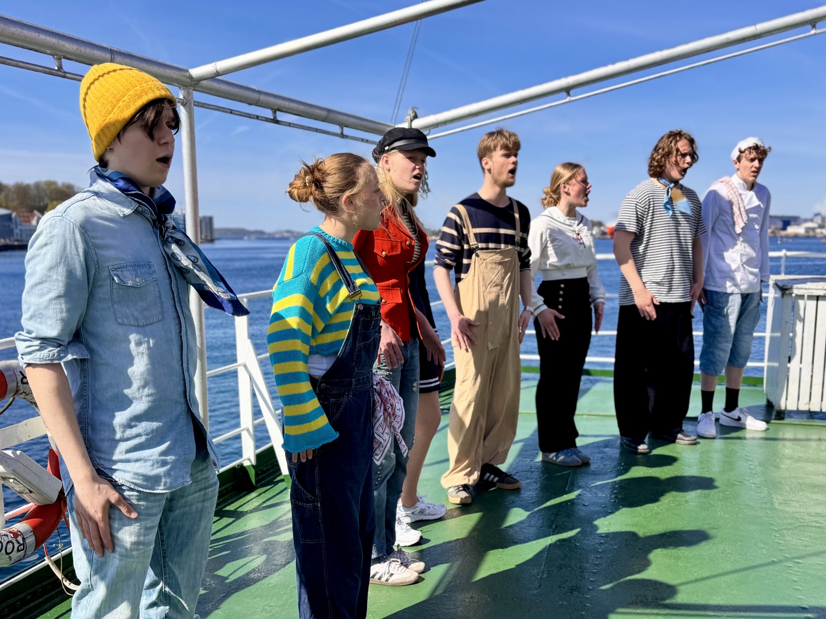 Mannskapet på MS Souvenir ønsker velkommen med en gammel engelsk sjanti, en arbeidssang, i strålende sol.