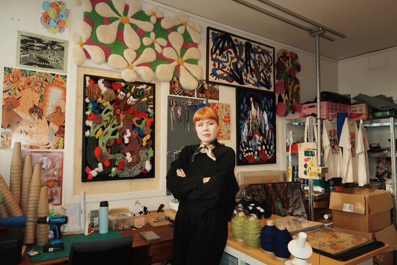 Johanna Warberg smiler foran noen av hennes verk. 