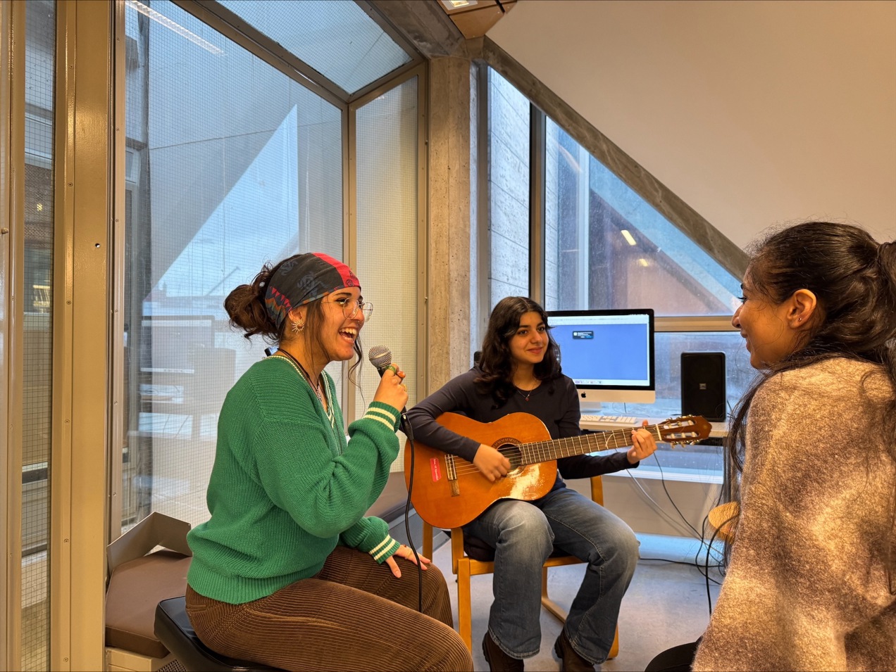 tre venninner som spiller musikk og synger i mikrofon