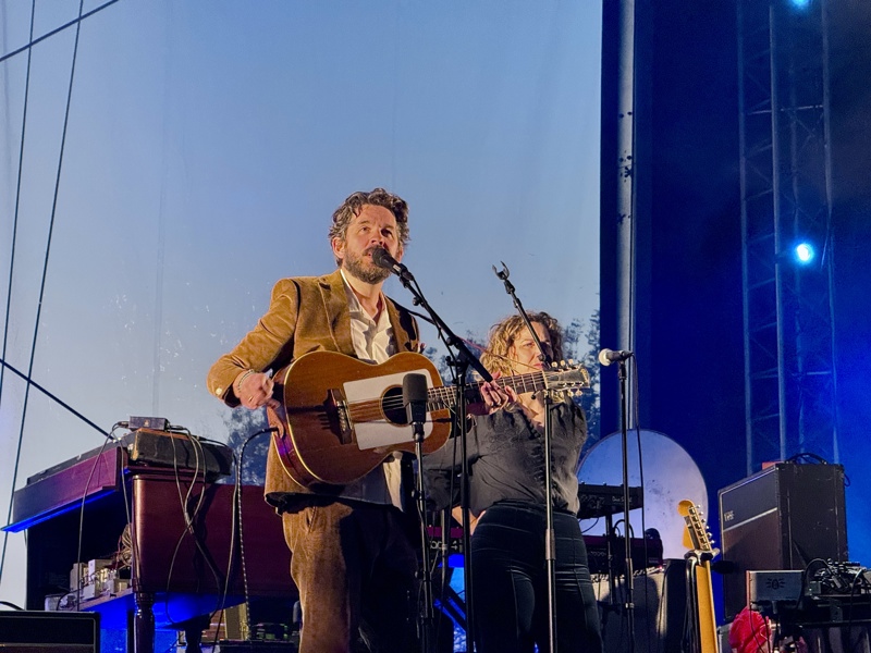Thomas Dybdal står på scenen og ser utover folkemengden. Han holder en gitar. 
