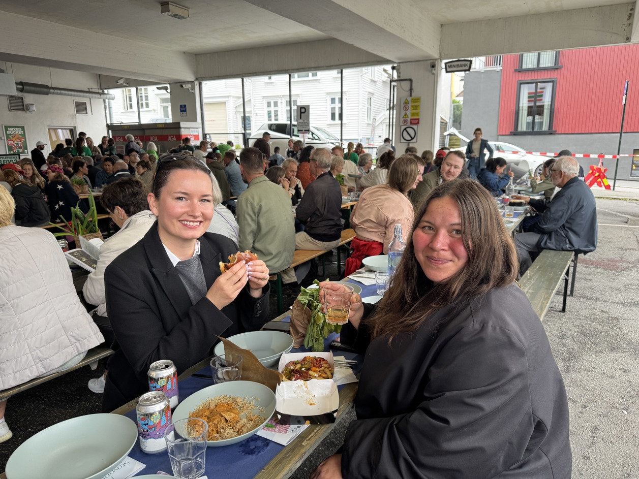 To venninner sitter på langbord og spiser middag på Blåsenborg.