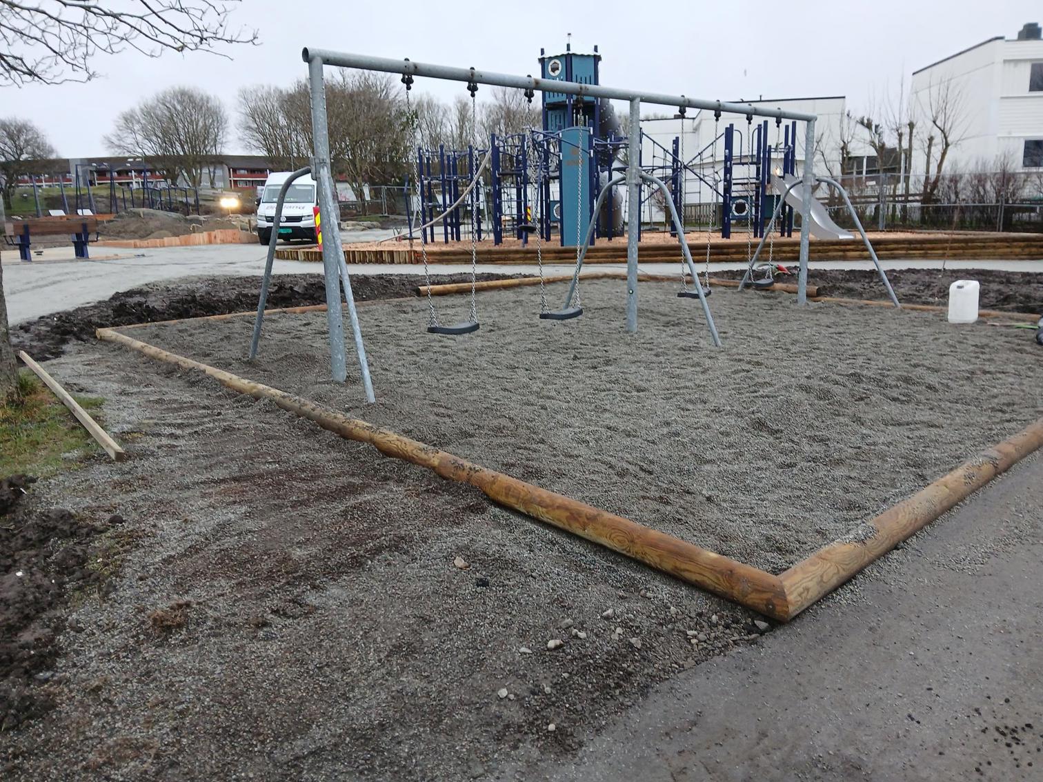 Uferdig lekeplass. Disser i forgrunnen. Lekeslott i bakgrunnen