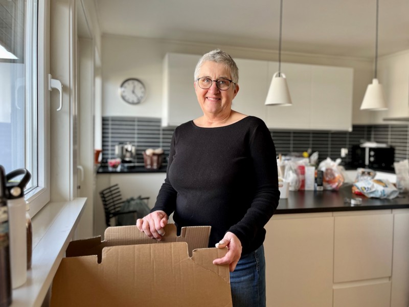 Bildet viser Anne Kjersti Medhus som står ved flytteeskene på kjøkkenet.