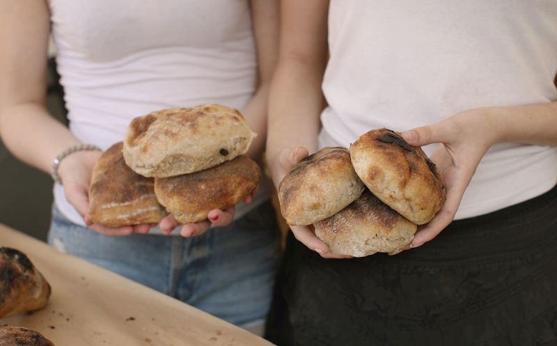 to personer som hoder rundstykker i hendene