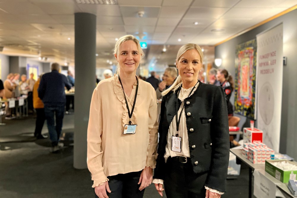 Bildet viser Bente Dahle Tysland og Hanne M.K. Skjæveland. de står i foajeen på Clarion hotell. I bakgrunnen ser vi masse folk og mange stands.