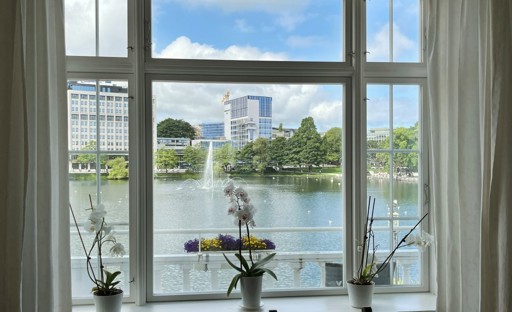 Vi ser et bilde av vinduet i Tante Emmas hus med utsikten mot Breiavatnet.