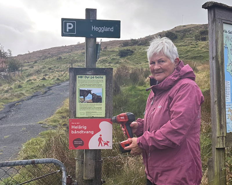Leder for turlaget på Rennesøy, Kirsti Løvik, fester nye båndtvang-skilt.
