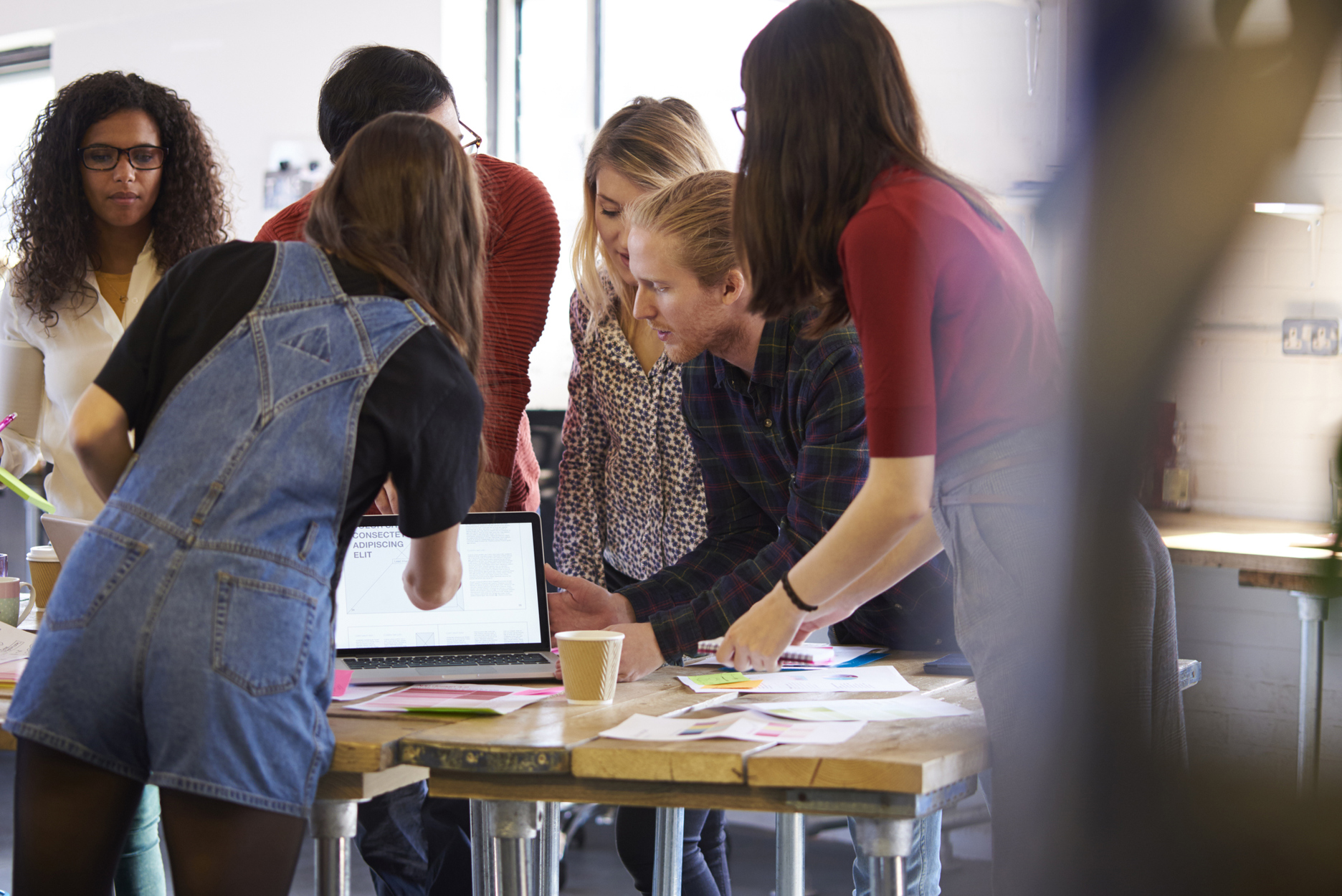 Gruppe unge mennesker som ser på en pc skjerm