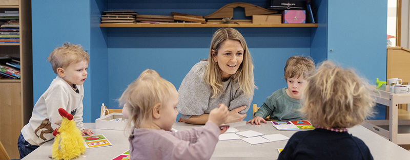 Ansatt i barnehage sammen med barn. 
