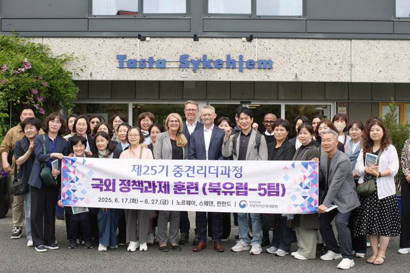 En delegasjon på 30 sørkoreanere, en politiker og to fra Stavanger kommune står bak et stort banner med sørkoreansk skrift.