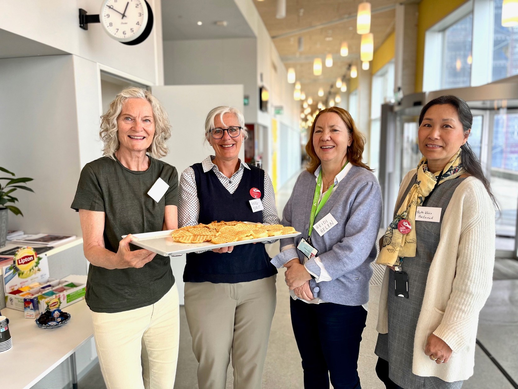 Vi ser fire damer som står, og smiler til kamera. Inger Elise Stensland og Inger Elise Johansson er begge frivillige, og holder et fat med vafler. de står sammen med Heidi Helen Nedreskår, og Ruth-Karin Haslerud, som jobber med demens i Stavanger kommune.