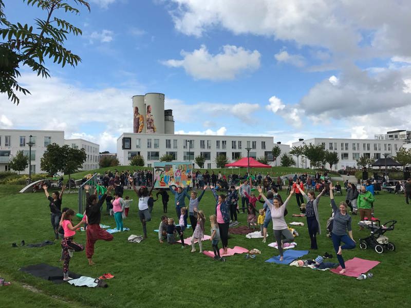 Yoga på Lervigfestivalen 2017, i parken med rekkehus i bakgrunnen
