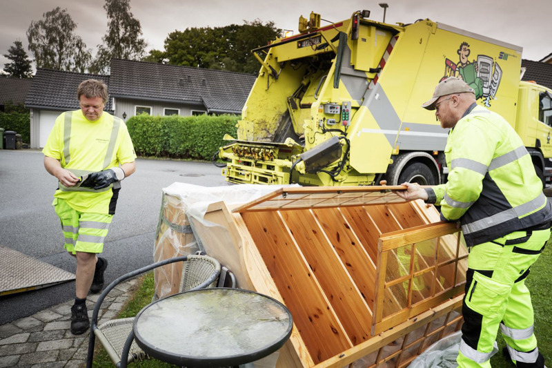 To renovatører bærer møbler fra gata inn i en kassebil