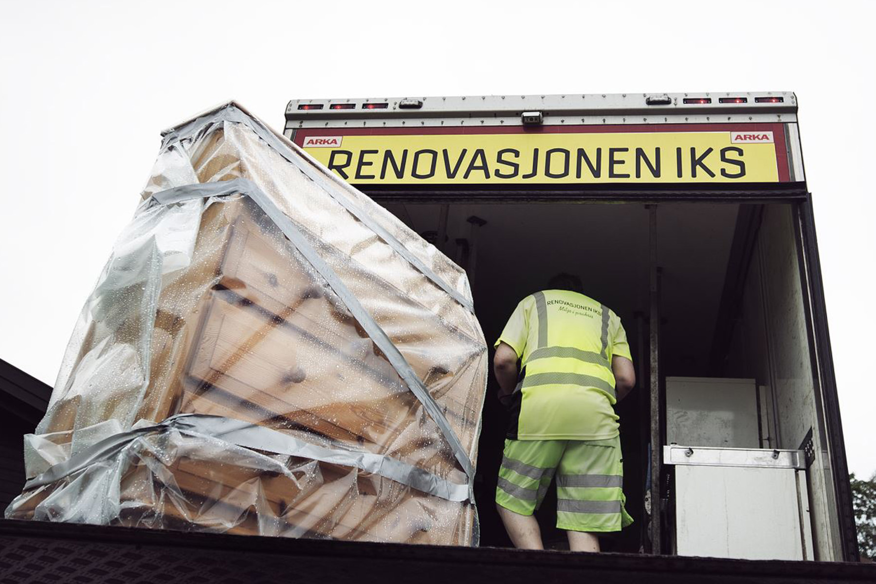 Kommode innpakket i plast står på lemmen bak en kassebil.