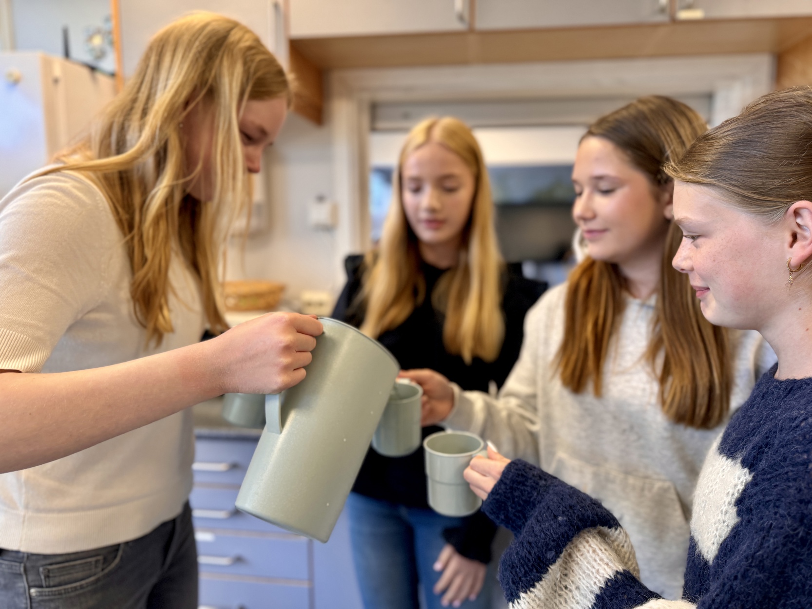 Pia P. Knudsen skjenker vann til venninnene Frida, Alva og Iben.