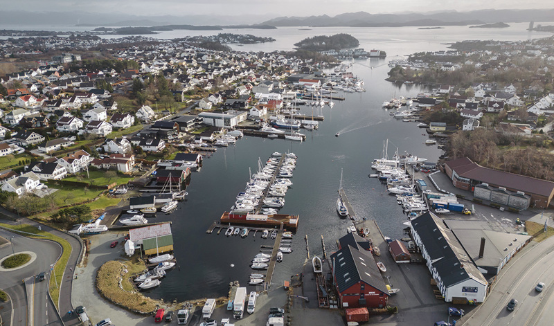 En våg med brygger og båter, omgitt av mange boliger og noen næringsbygg.