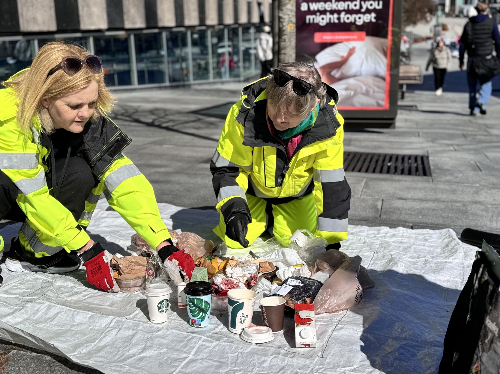 Gabriele Brennhaugen, klima- og miljø-rådgiver, og Kristin Kverneland, bykoordinator i NEB-STAR, plyndrer søppelet i sentrum. Innholdet fra to svære søppelspann tømmes på ut på medbrakt presenning.