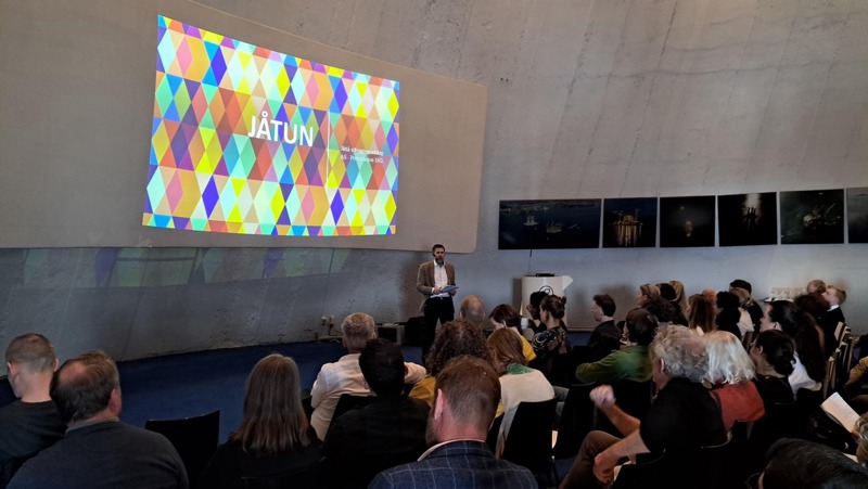 mange folk hører på en presentasjon av Jåtun