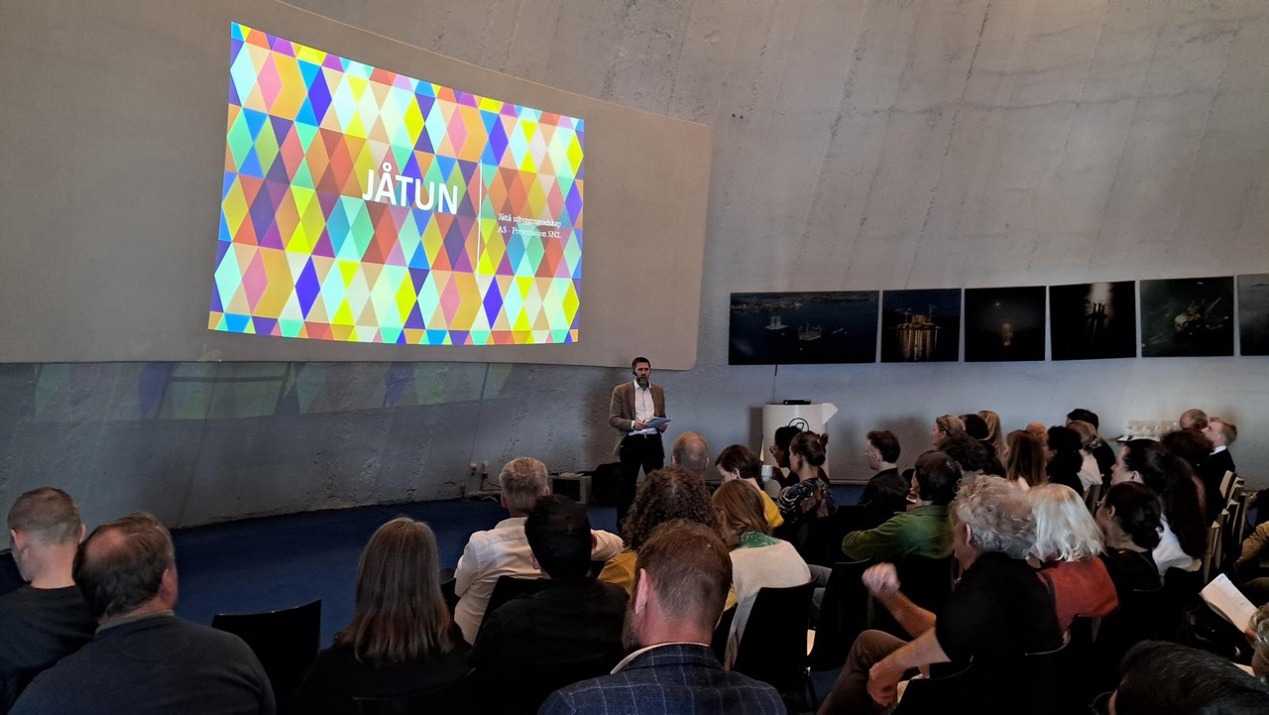 mange folk hører på en presentasjon av Jåtun