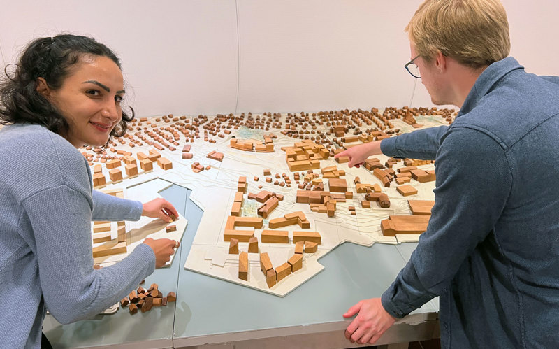 To arkitekter står bøyd over en bymodell over Stavanger.